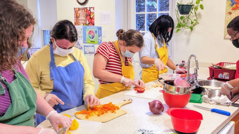 Students cutting and preparing ingredients in a kitchen